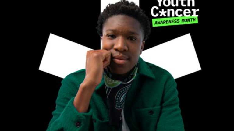 A young male looking into the camera, in front of the Youth Cancer Awareness Month logo