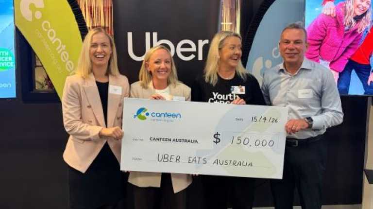 Canteen, UberEats and YCS representatives holding a large cheque