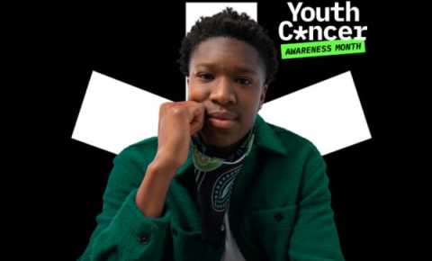 A young male looking into the camera, in front of the Youth Cancer Awareness Month logo