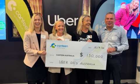 Canteen, UberEats and YCS representatives holding a large cheque