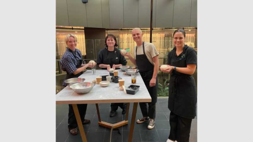 four young people making pizza dough